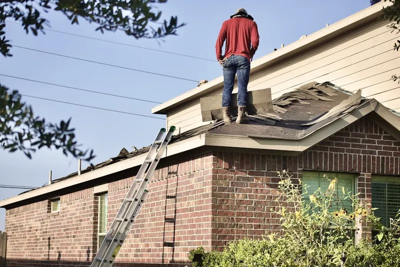 Professional roofer working on a residential roof in Una